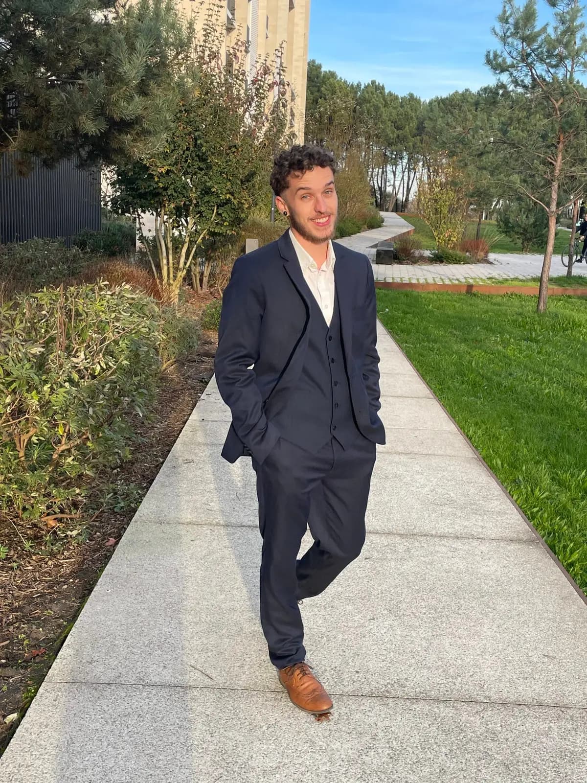 Aaron Maître, fondateur de Bindzen, en costume, marchant dans une allée