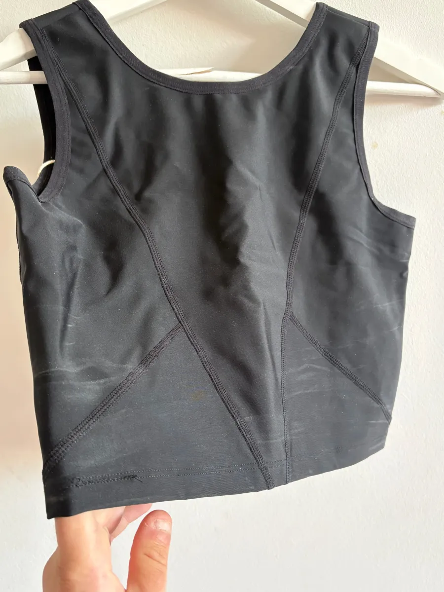Exemple de binder noir refusé au retour : dos porté, avec des traces blanches de sueur et des marques d'utilisation sur le tissu